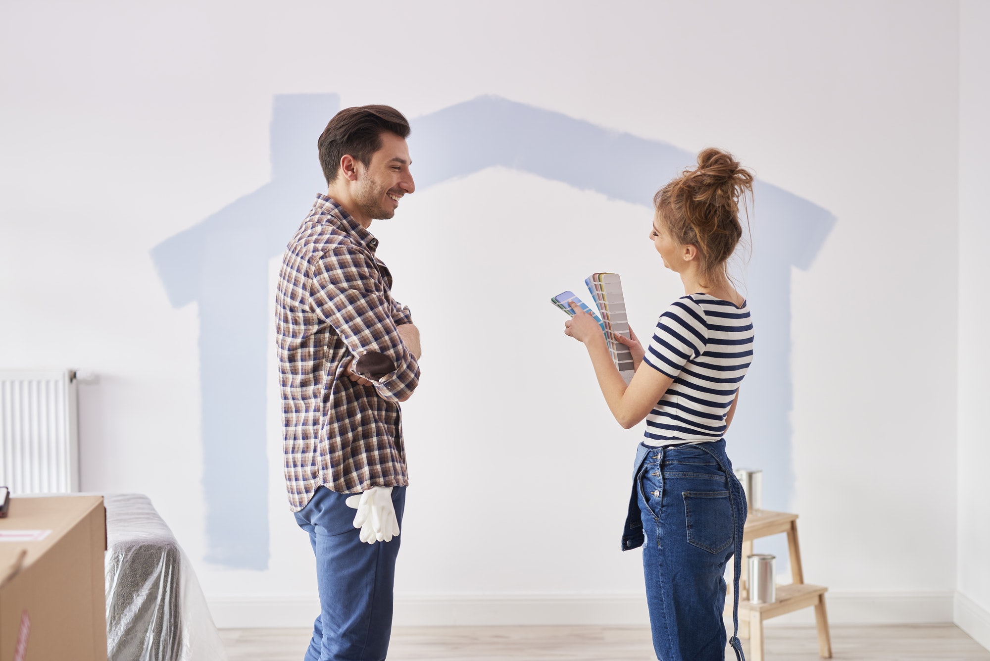 couple painting the interior wall in their new apartment